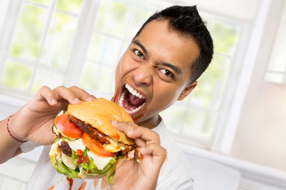 Seorang pria sedang memakan burger