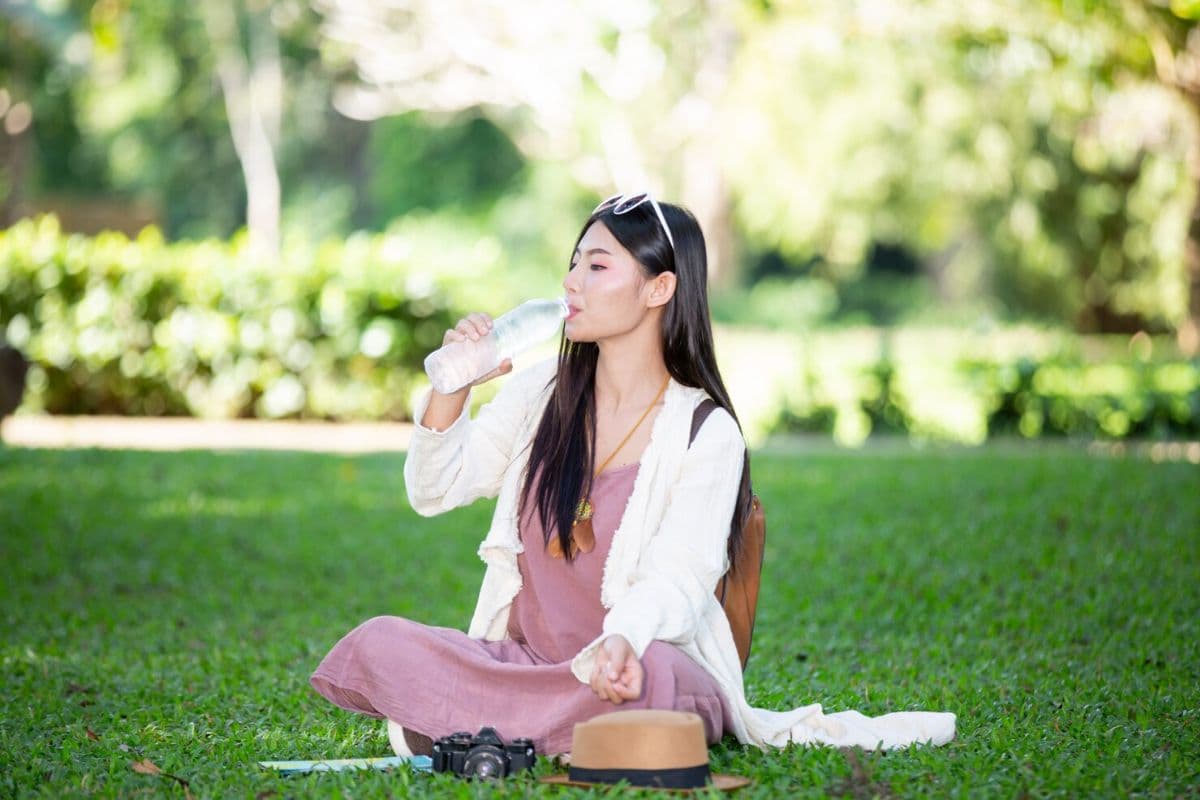 Perempuan duduk di atas rumput