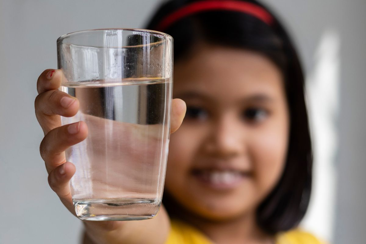 Anak perempuan menunjukkan segelas air