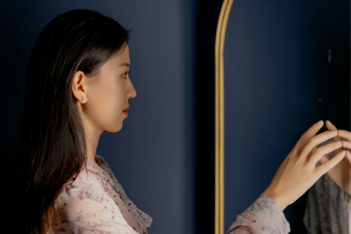 seorang perempuan mengaca