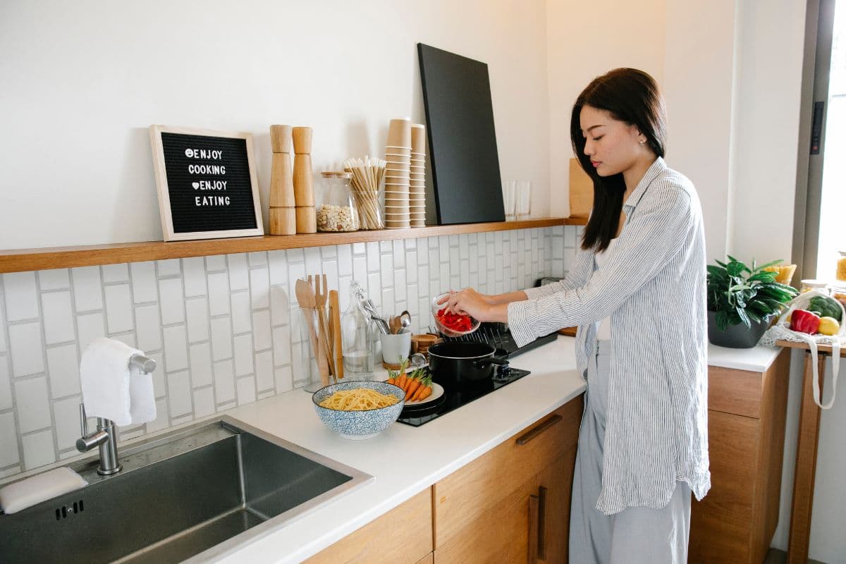 Perempuan sedang memasak di dapur
