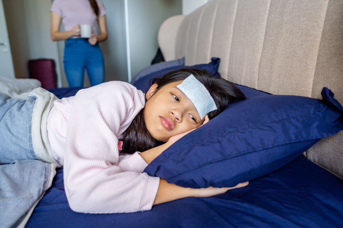 Anak perempuan sedang menggunakan kompres di dahi