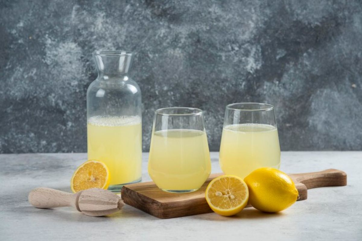 Tiga gelas air lemon dengan irisan lemon di sekitarnya