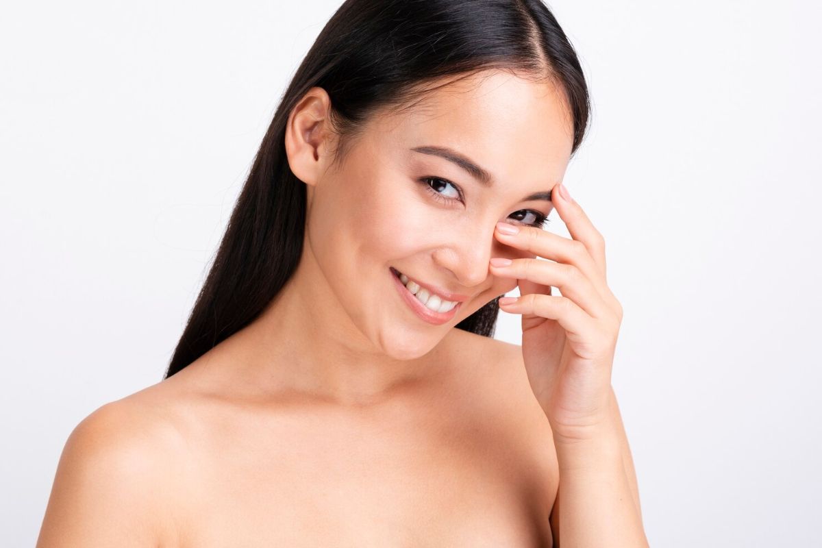 Perempuan menyentuh kulit wajahnya yang sehat