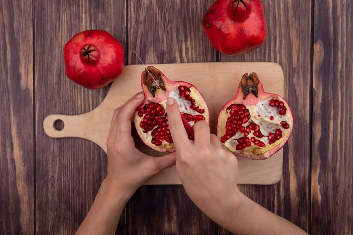 Perempuan memotong buah delima