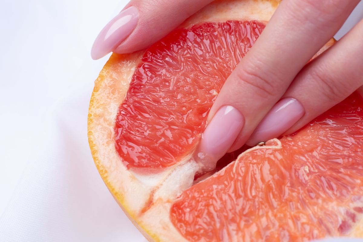 Tangan wanita di buah jeruk