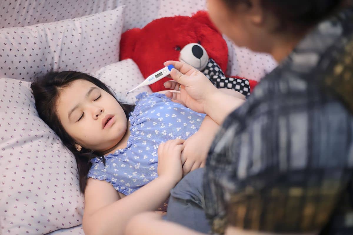 Ibu mengambil termometer dari anak