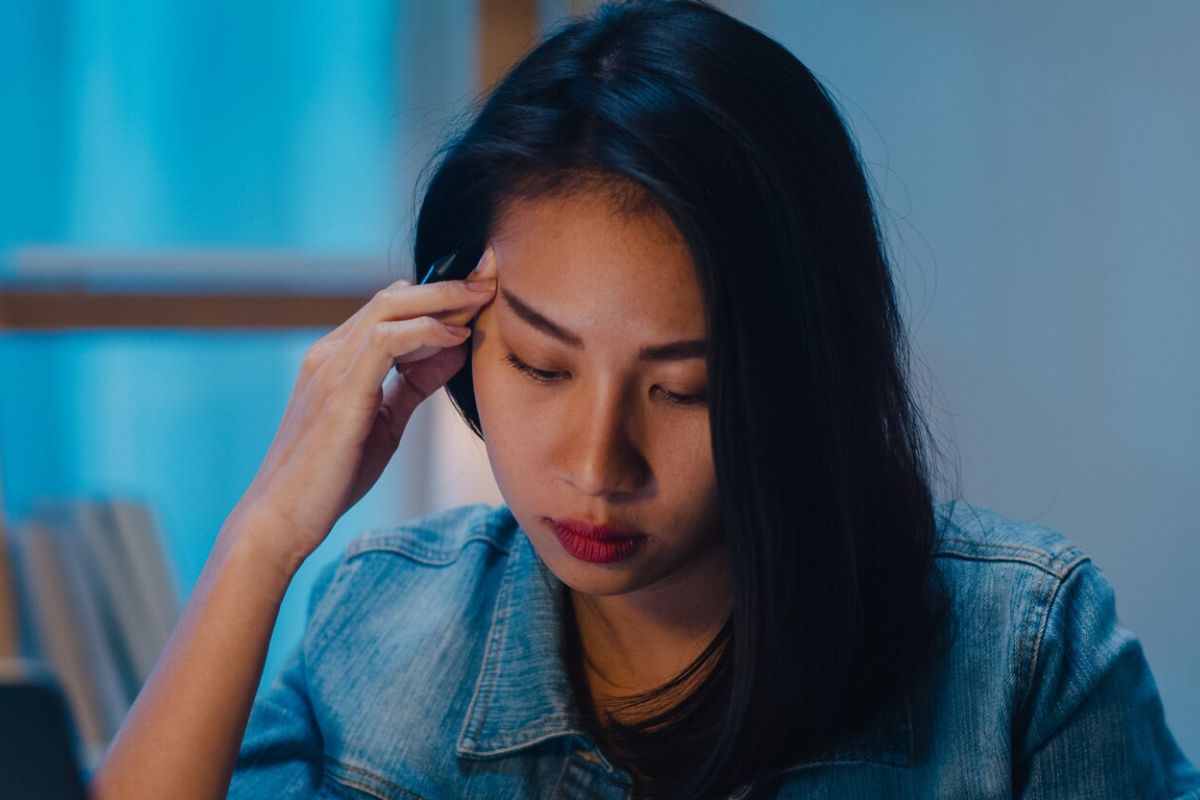 Perempuan memijat pelipisnya