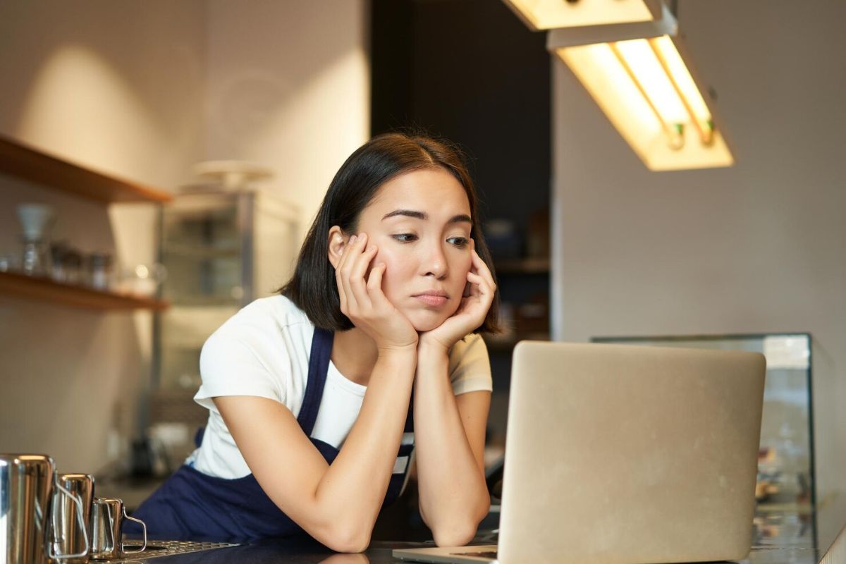 Perempuan menatap layar laptopnya