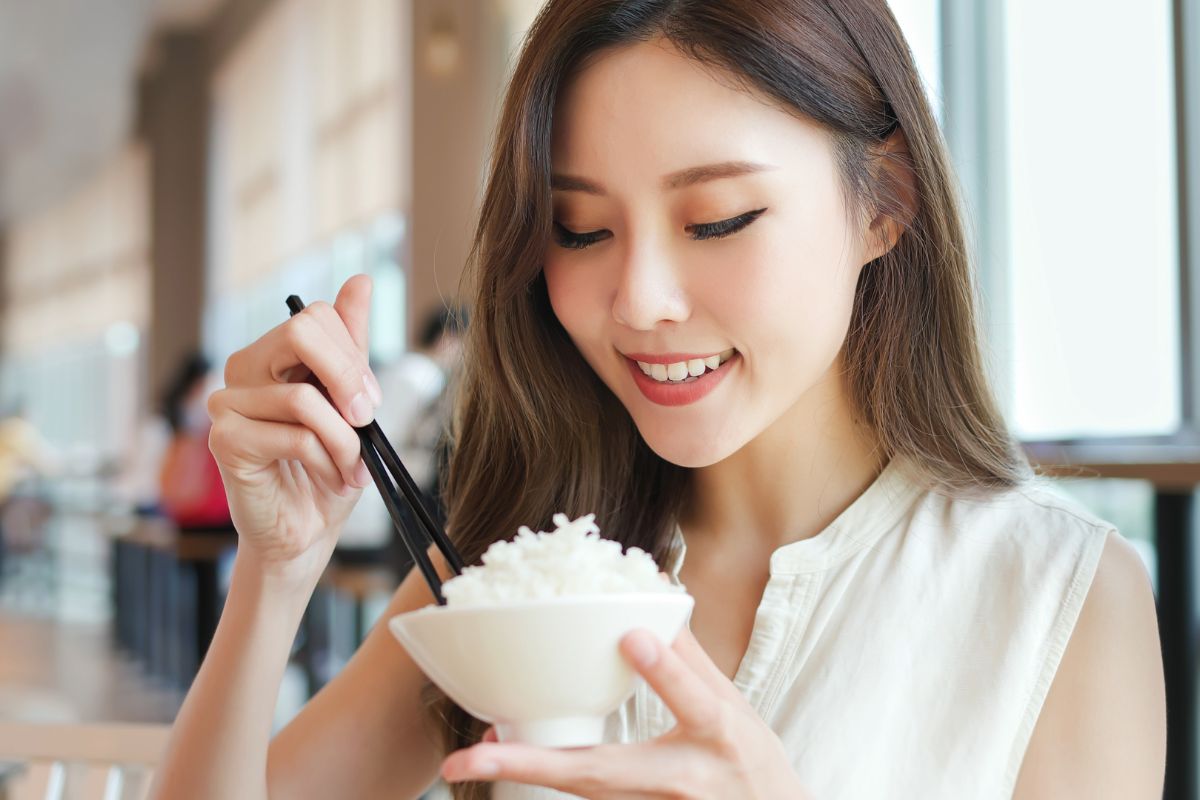Wanita sedang memakan nasi