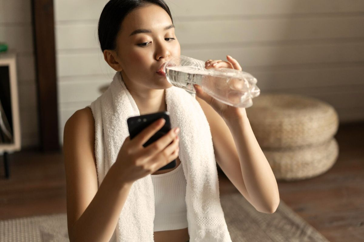 Wanita sedang meminum air mineral