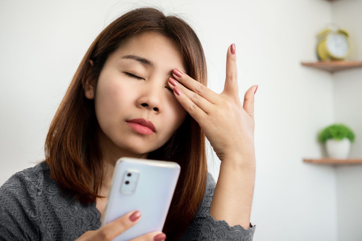 seorang wanita tengah mengucek matanya karena lelah setelah menatap layar