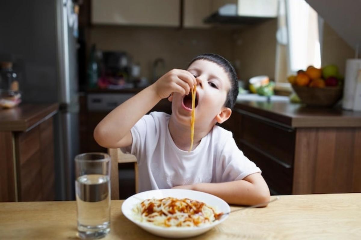 Anak laki-laki makan dengan tangannya