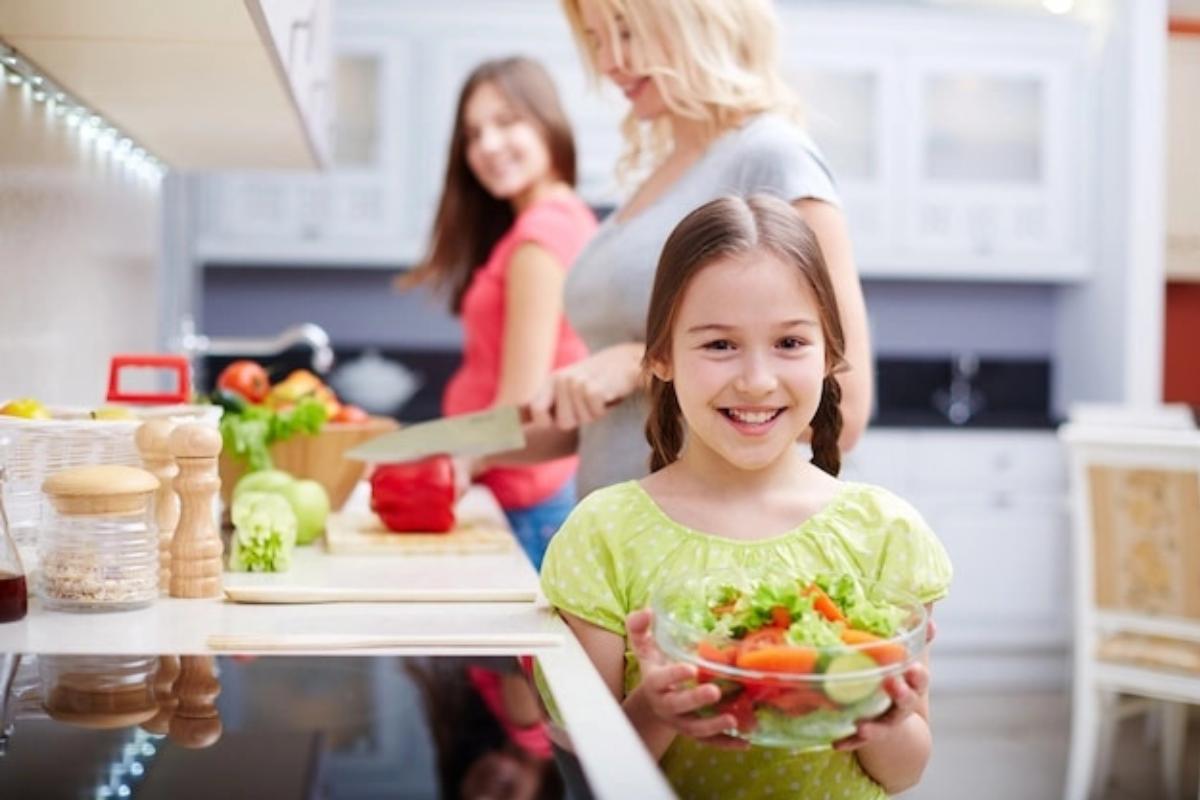 Anak tersenyum membawa semangkuk salad