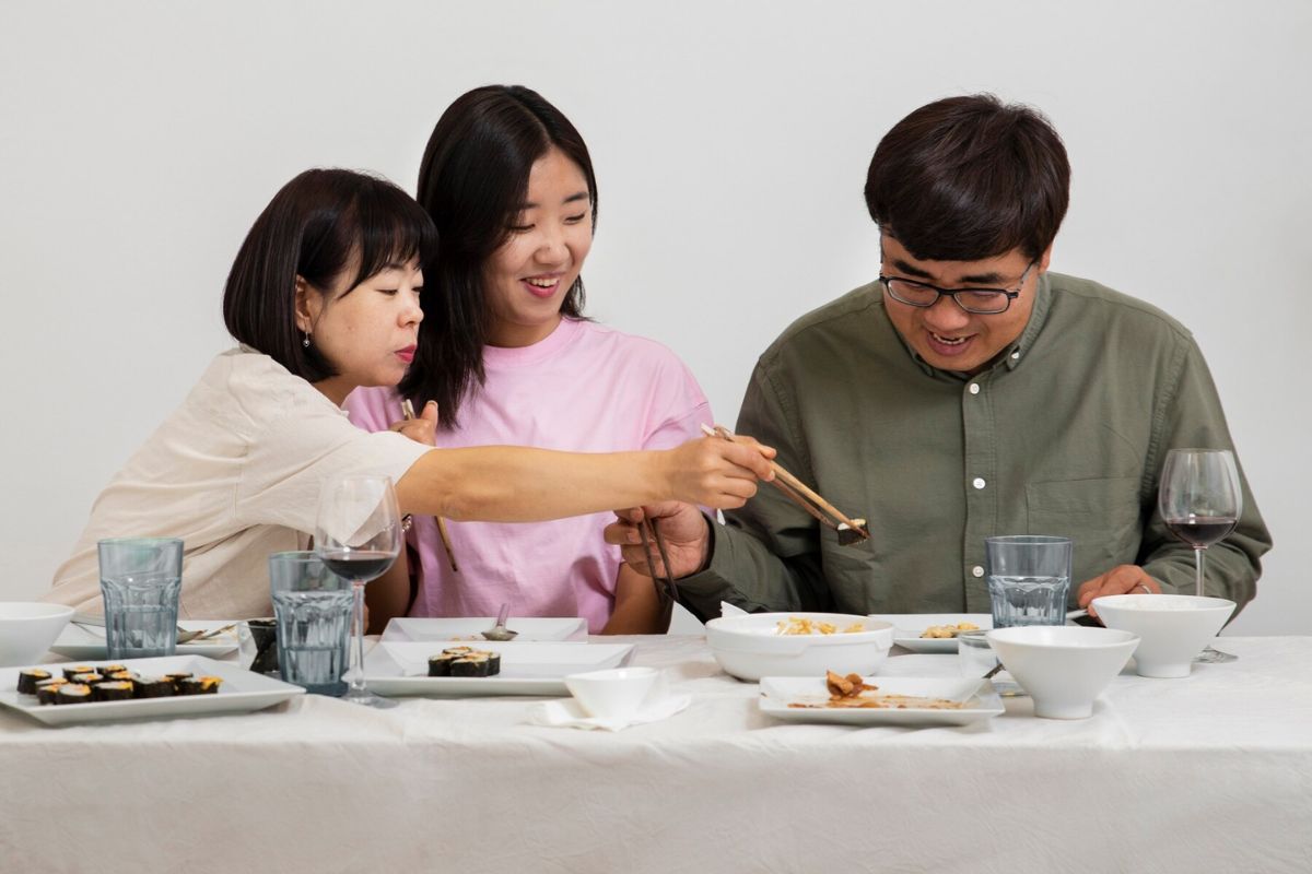 Ayah, ibu, dan anak sedang makan bersama
