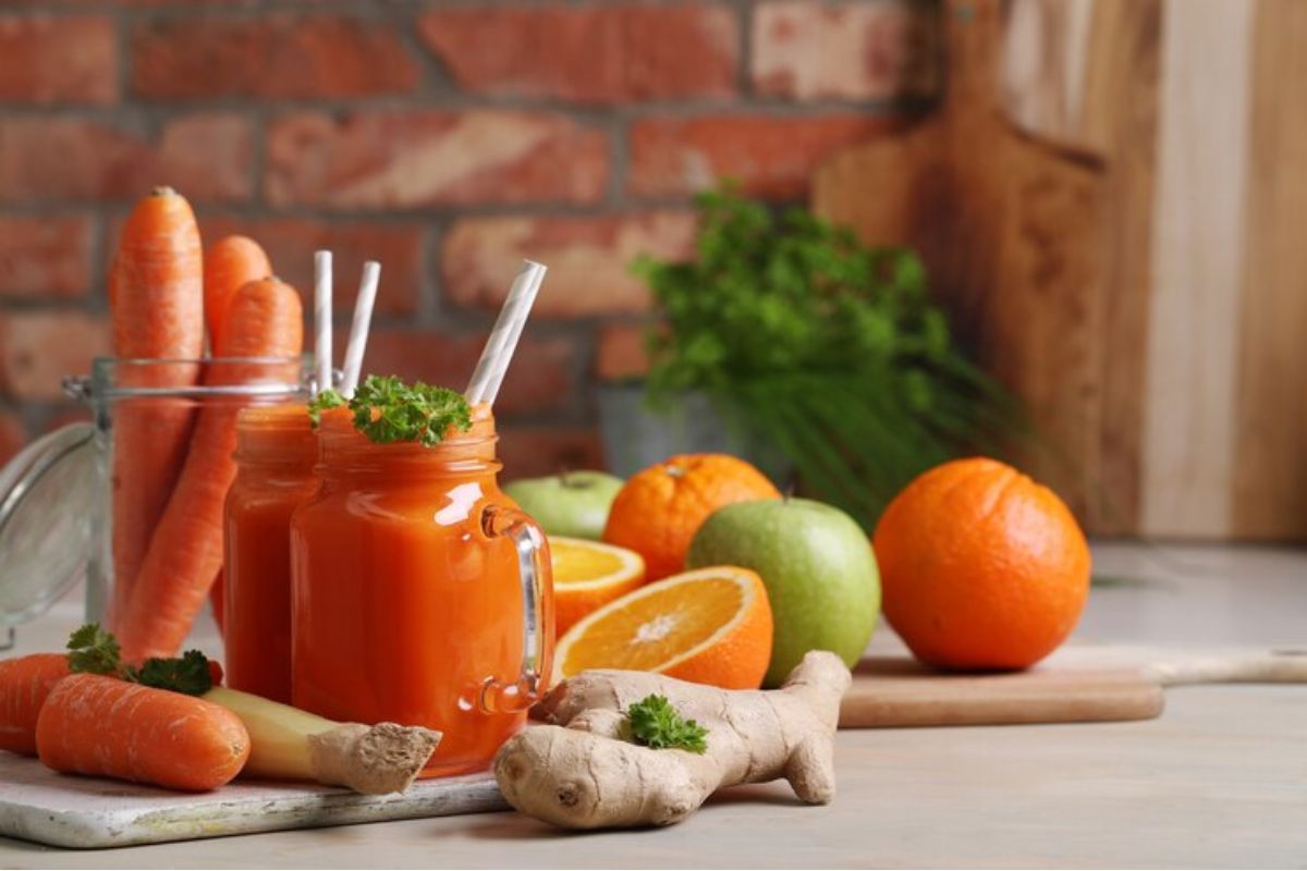 Dua gelas jus dan buah-buahan dan sayur-sayuran di sekitarnya