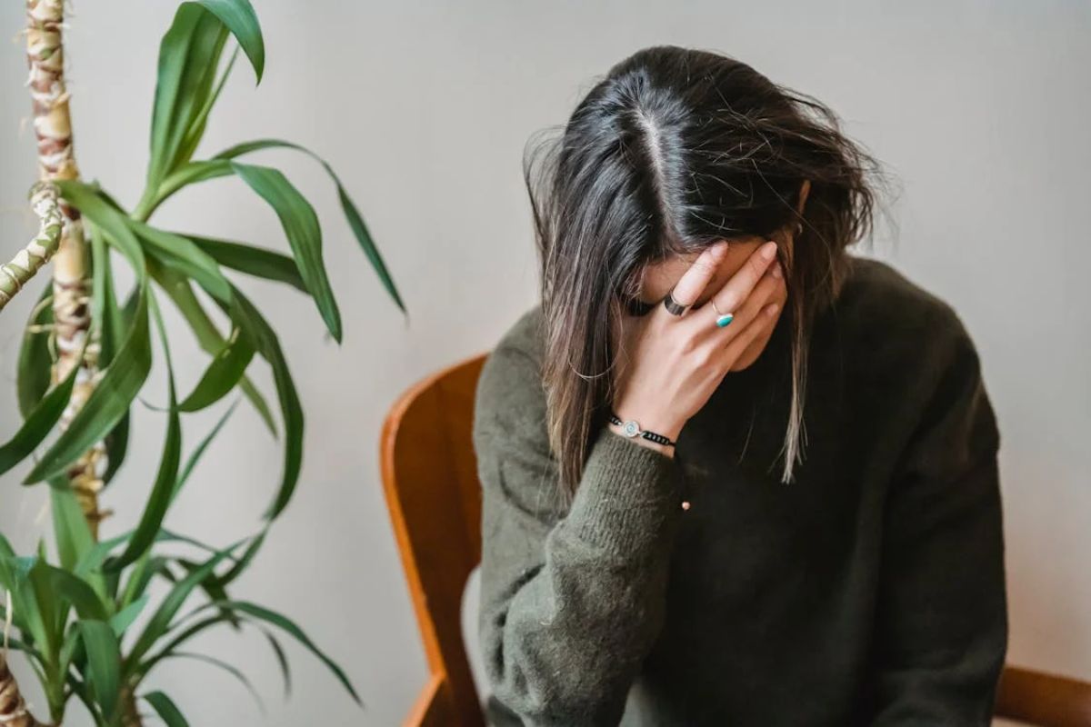 Perempuan menutupi mukanya dengan tangan