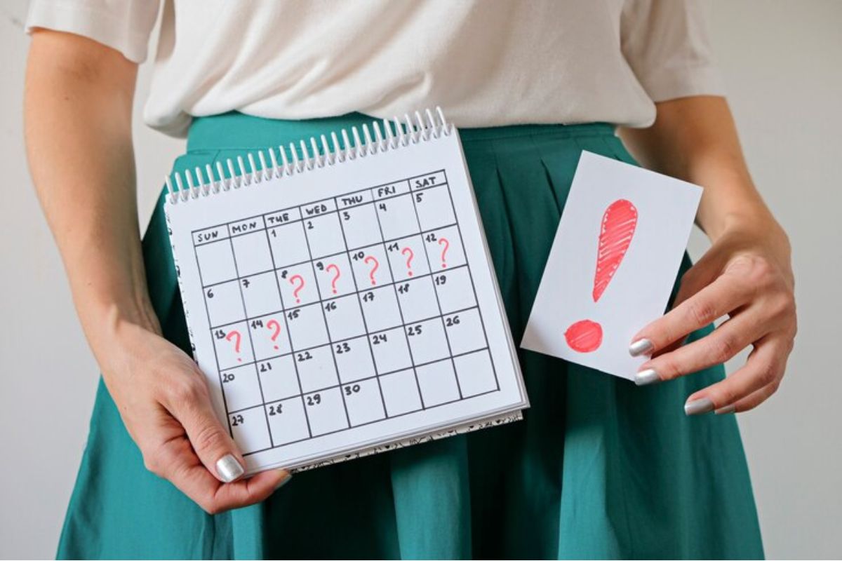 Close up seorang wanita sedang memegang kalender dan note bertuliskan 