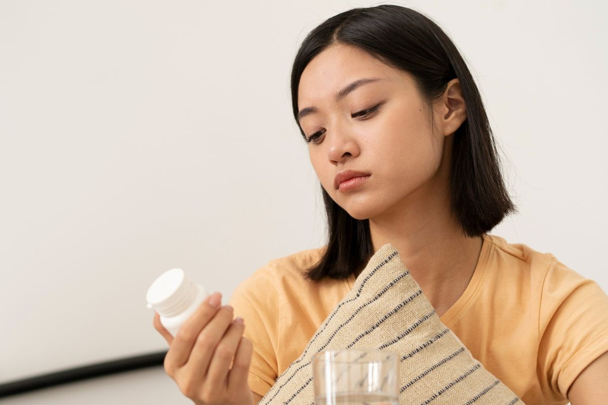 Wanita sedang membawa botol suplemen 