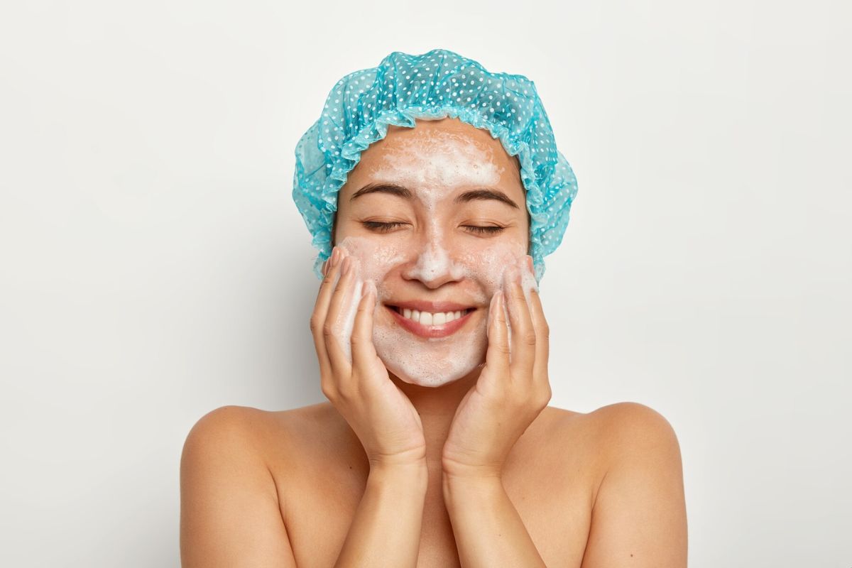 Seorang wanita sedang memakai sabun cuci muka dengan kandungan Salicylic Acid