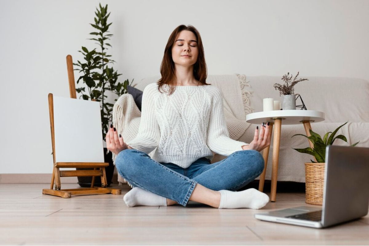 Perempuan meditasi di depan laptop
