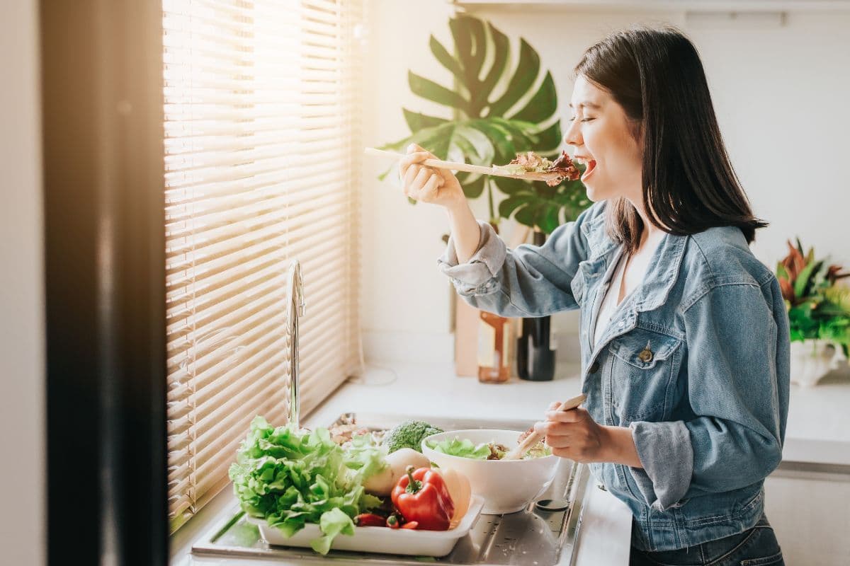 Wanita sedang memakan salad