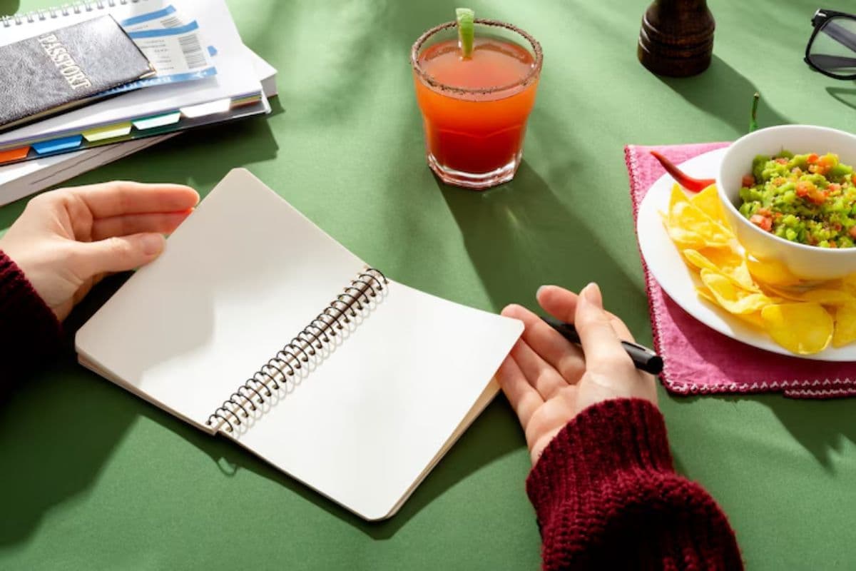 Seorang wanita membuka buku catatan di meja makan