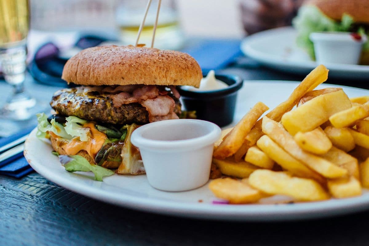 sepiring junk food berupa burger dan kentang goreng