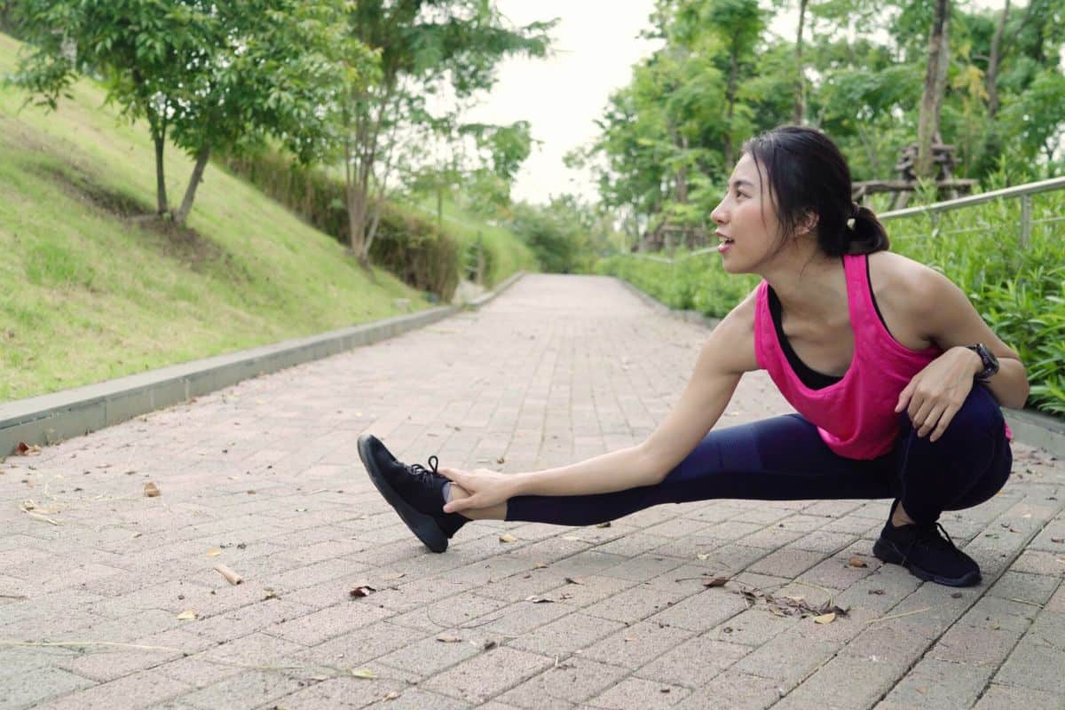 Wanita sedang pemanasan di taman