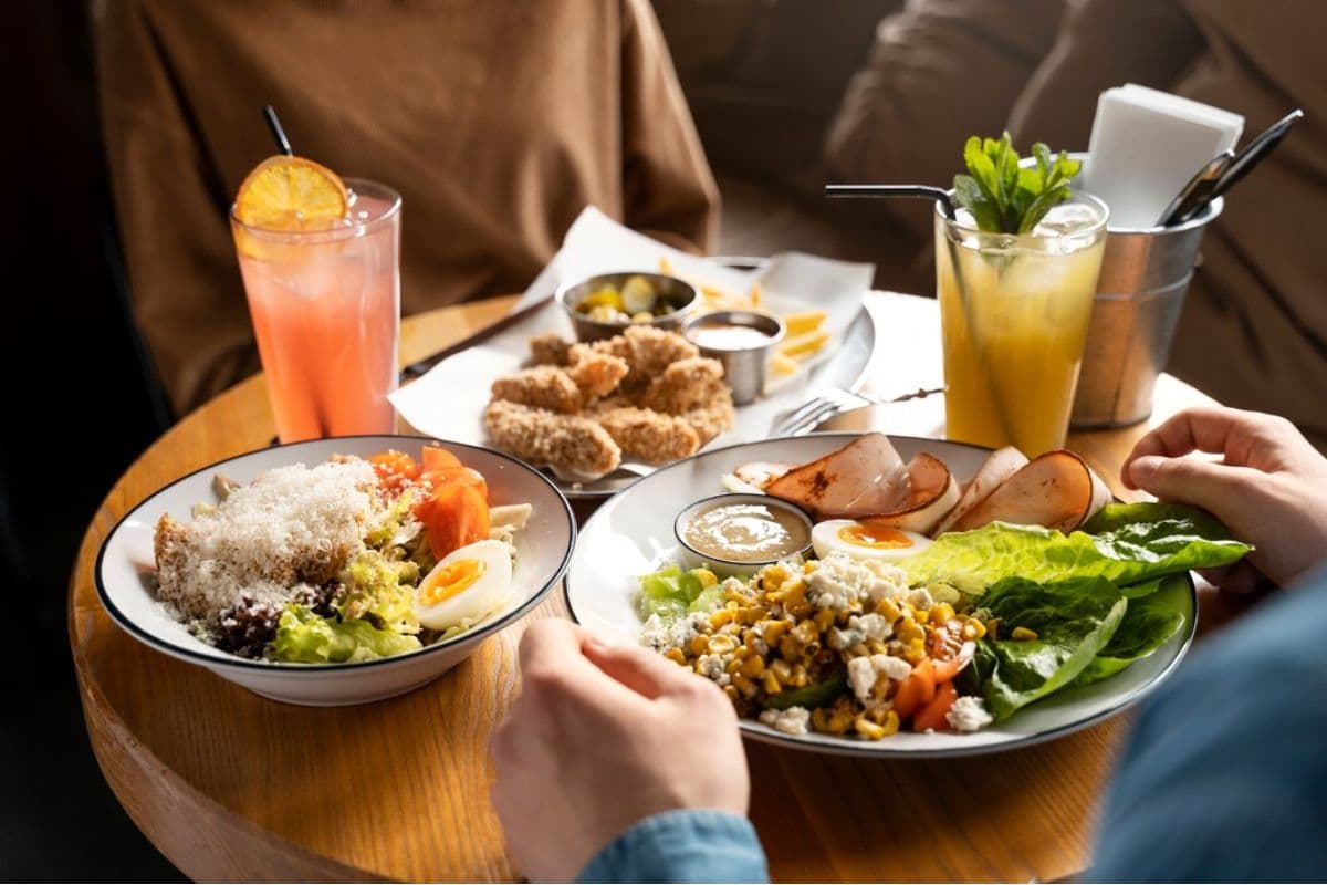 Dua orang dewasa menikmati makanannya