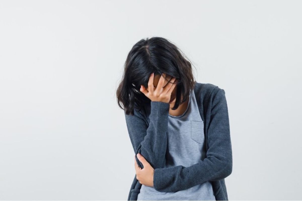 Seorang perempuan memegang kepala karena stress