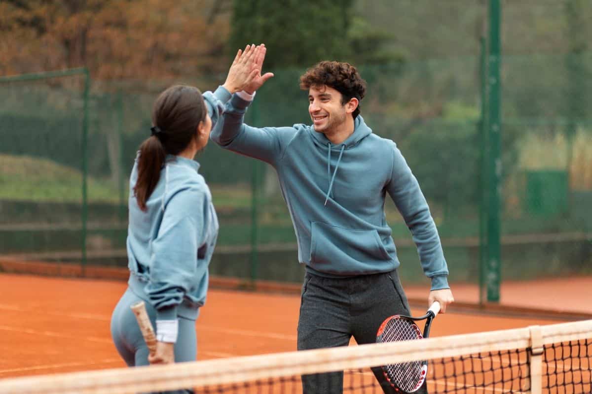 Pria dan wanita sedang bermain tenis