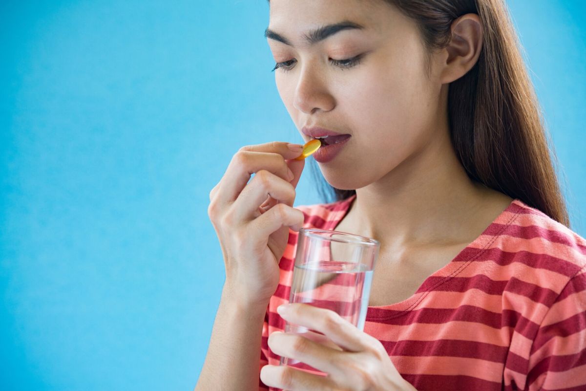 Seorang wanita meminum vitamin E