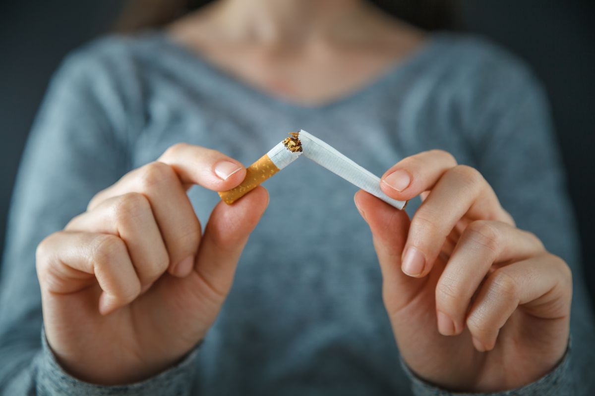 Seorang wanita mematahkan batang rokok