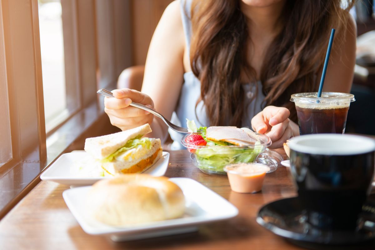 Seorang wanita sedang makan di cafe