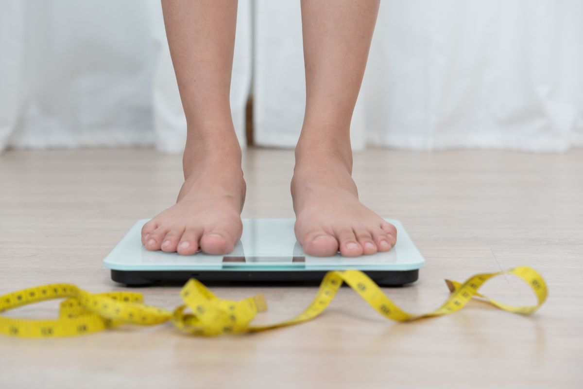 Potret kaki wanita yang sedang menimbang badan