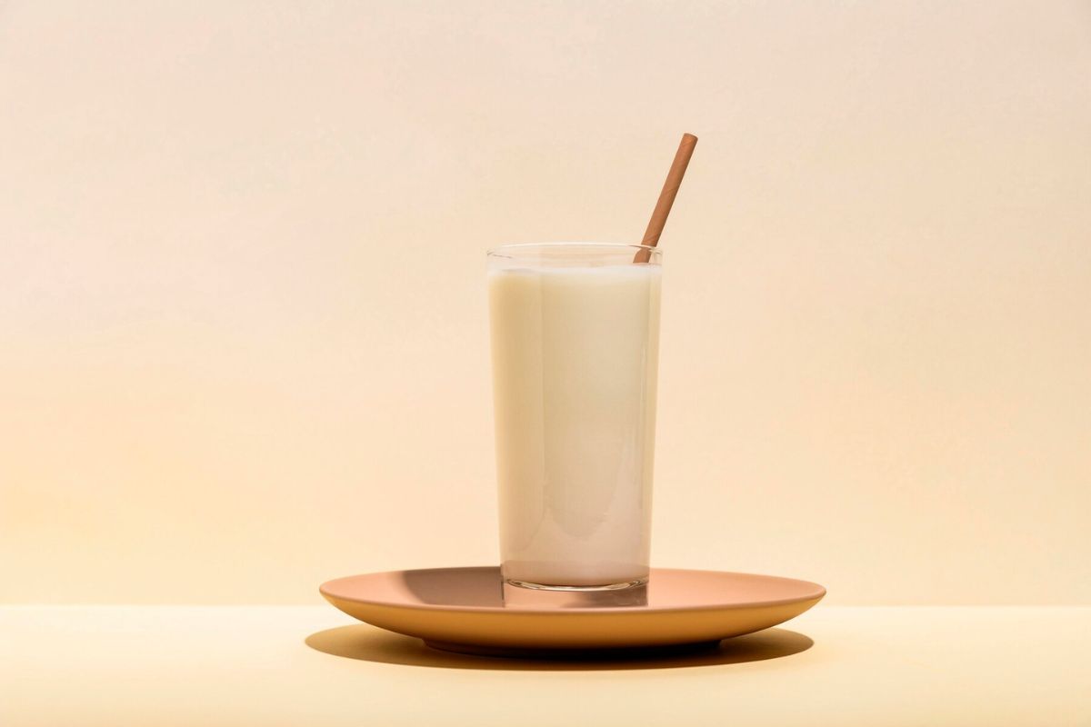 Segelas minuman yogurt dengan sedotan kayu